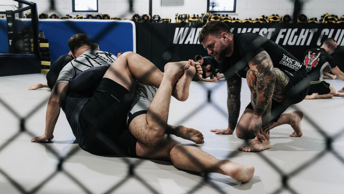 Mężczyźni trenujący grappling z trenerem